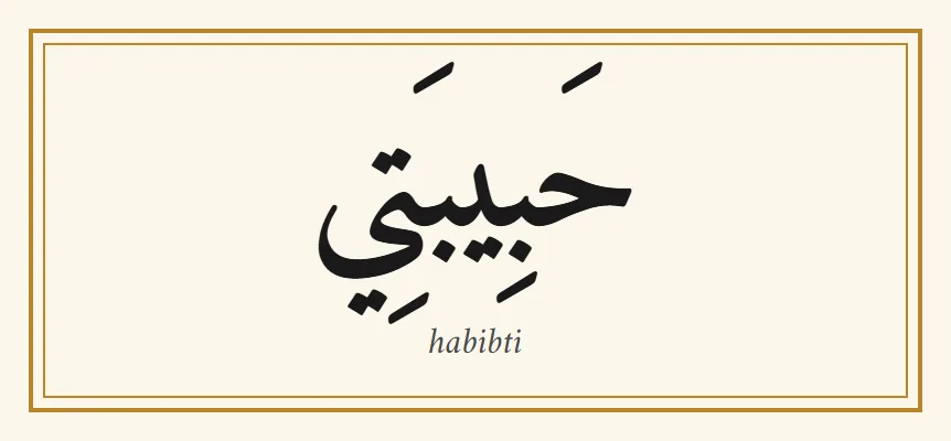Le mot arabe habibti, حبيبتي, en lettres naskh noires avec ses signes de voyelles, et la translittération habibti en dessous, dans un fin cadre doré sur fond crème