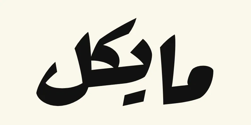 The name Michael in Arabic, مايكل, in black heavy poster lettering from the Rakkas font on a cream background